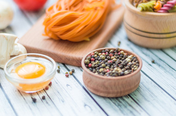 Still life with pasta ingredients on the wooden background