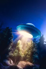 Behangcirkel Hoog contrastbeeld van UFO die & 39 s nachts over een bos vliegt met een lichtstraal © fergregory