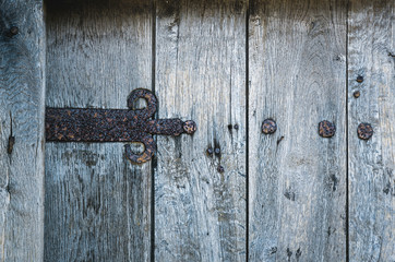 part of old wooden gate with rusted iron hinge