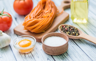 Still life with pasta ingredients on the wooden background
