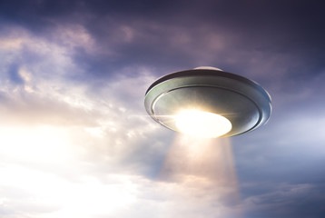 UFO with abduction beam flying in the sky
