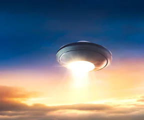 Draagtas UFO met ontvoeringsstraal die in de lucht vliegt © fergregory