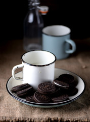 Cup of milk with chocolate cookies.Rustic style.