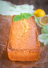 Lemon pound cake with mint on wooden background