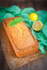 Lemon pound cake with mint on wooden background