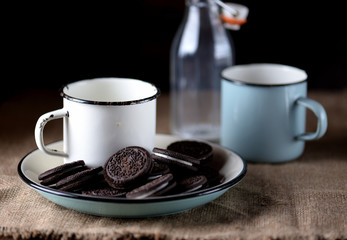 Cup of milk with chocolate cookies.Rustic style.