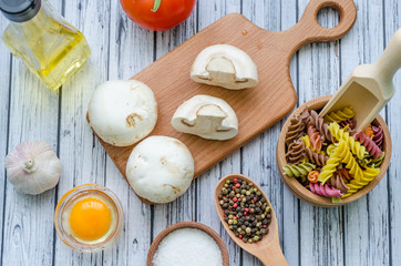 Still life with pasta ingredients on the wooden background