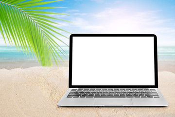 A laptop on the sea beach with coconut tree.