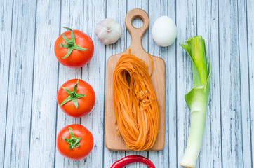 Still life with pasta ingredients on the wooden background