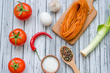 Still life with pasta ingredients on the wooden background