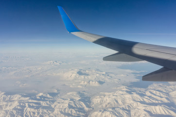 Plane wing and mountains in a beautiful landscape