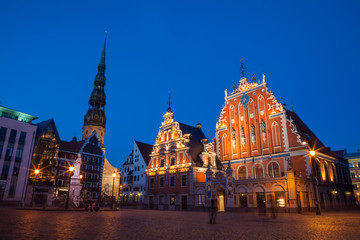 Obraz premium RIGA, LATVIA - 12 JUN 2016: City Hall Square with House of the Blackheads and Saint Peter church in Old Town at evening