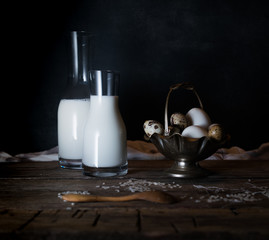 Fresh organic eggs, milk and butter, still life in rustic style, vintage wooden background.