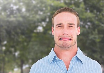 Man crying against trees