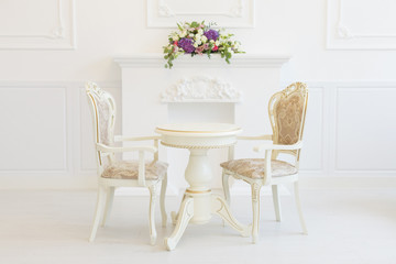 Bright luxury white interior living room with flowers . the walls are decorated with baroque ornaments