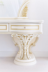 White dressing table in a living room. Modern classics with rococo elements. Decorated with molding in the style of Renaissance, Baroque.