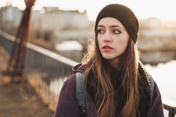 Hipster girl walking on the bridge at sunset