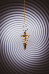 Pendulum used for readings and hypnotism on swirl background