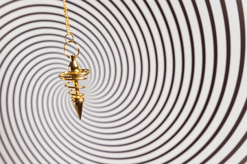 Pendulum used for readings and hypnotism on swirl background
