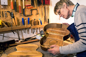 Luthier checking the body of an acoustic guitar