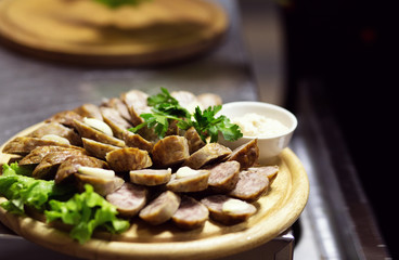 Baked traditional homemade sausage with spices and herbs on the wooden cutting board