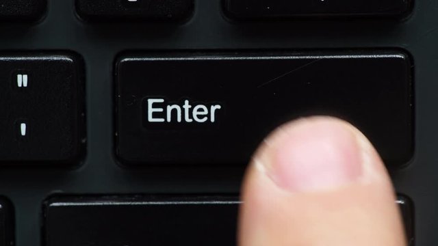 Male finger pressing pushing enter button key. Black computer keyboard detail view closeup 4K ProRes HQ codec