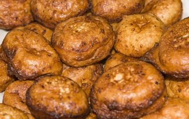 Donuts frying in deep fat. Preparation of traditional donuts