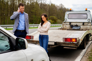 Couple near broken car on a roadside