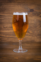 Lager beer in glass on wooden background