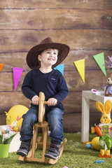 Sweet little boyplaying a t home with wooden horse. Little cowboy