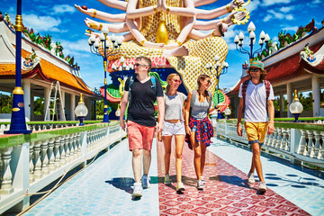 Obraz premium group of tourists exploring buddhist temple in thailand