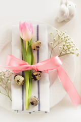 Elegance table setting with pink ribbon and tulip on white background. Easter romantic dinner. Top view.