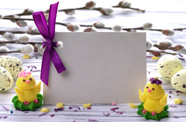 Easter Background with yellow easter eggs pussy willow branches purple ribbon and little chickens space for text.