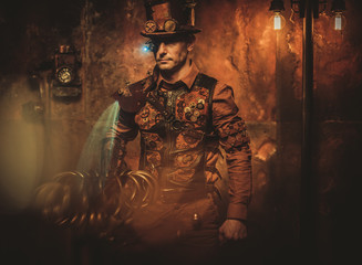 Fototapeta na wymiar Steampunk man on vintage steampunk background