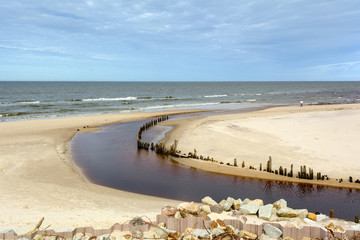 Beautiful sandy beach in Karwia village and wooden breakwater next to the mouth of Karwianka river. Poland.