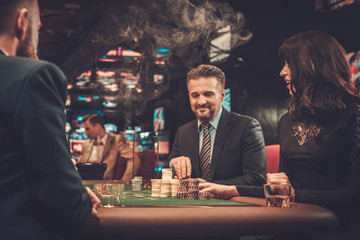 Upper class friends gambling in a casino