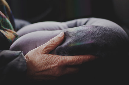 Old woman's hands holding the travel pillow