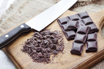 Chopped dark chocolate on wooden cutting board