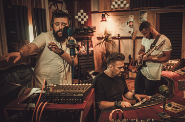 Professional music band recording song in boutique recording studio