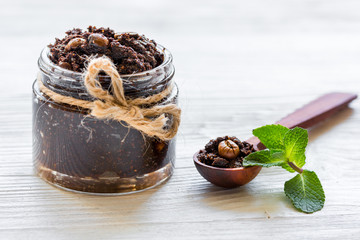 Body scrub of ground coffee on white table background