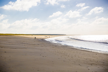 sandy beach in Vendee, France with blue sky and white clouds