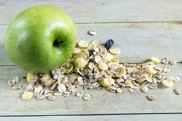 Foods for healthy eating: apple, cereal on light wood background