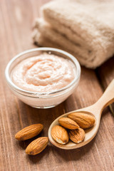 cosmetic set with almond scrub on table background