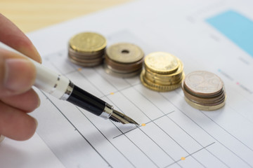 Finances statement with Pen,hand pointing pen on financial charts, paper work in the office,Finance Business,discussing on stock market charts pens pointing at business document during discussion