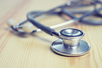 Stethoscope on wooden table,acoustic medical device for auscultation, or listening to the internal sounds of an animal or human body,used to listen to intestines and blood flow in arteries and veins.
