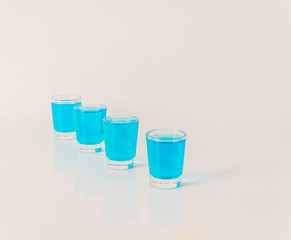 Four glasses of blue kamikaze, glamorous drink, mixed drink poured into shot glasses