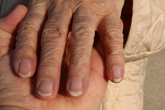 Hands, 50 years old woman holds the Hand of a 90 years old woman (upper Hand), 50 jährige hält die Hand einer 90 jährigen, Symbolfoto für Pflege, Senioren
