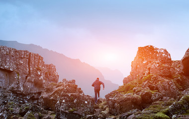 Fracture of tectonic plates in tingvellir park in Iceland. Cloudy autumn day. The man runs up the...