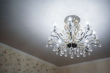 Modern crystal chandelier hangs from ceiling