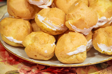 Close up of resh homemade profiteroles with cream